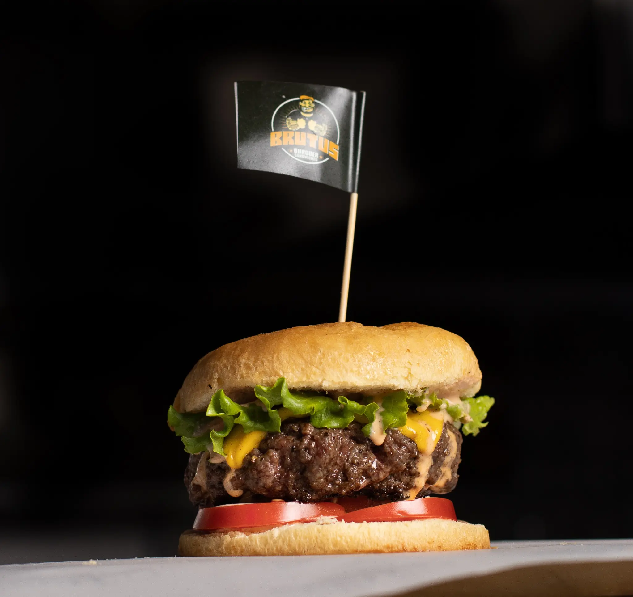Hamburguesa artesanal fotografiada sobre fondo negro